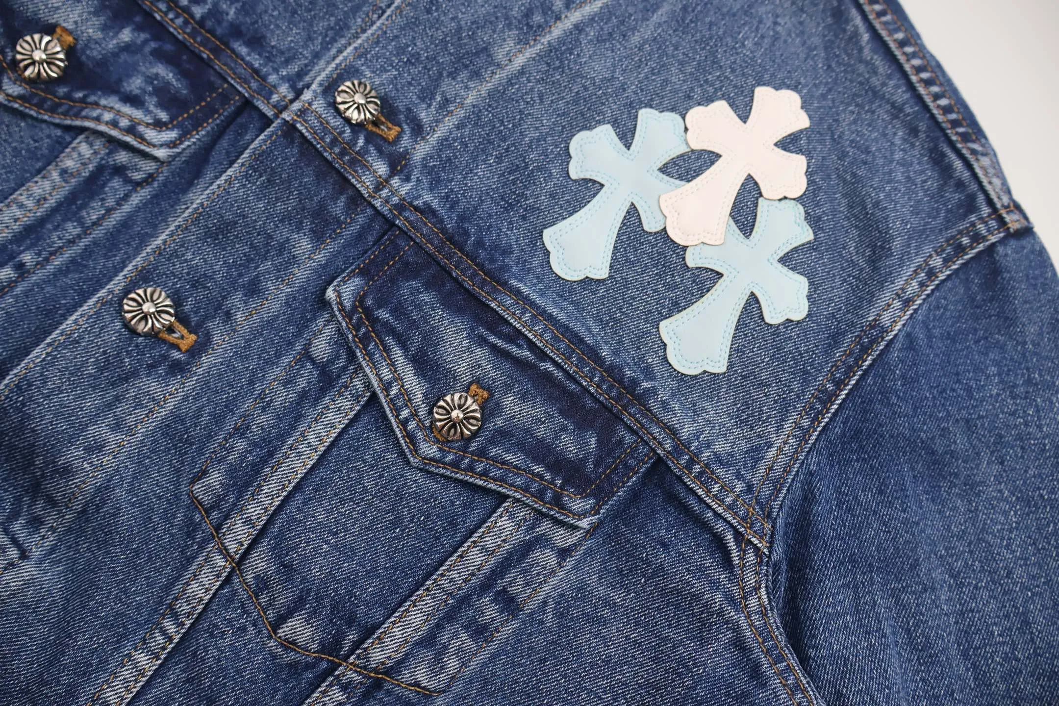 🅿️810 [Exclusive supply] CH Crow Heart Sleeve Cross-Flat Denim Jacket This denim jacket takes the brand's iconic cross element as its core, and stages a wonderful dialogue between hardcore aesthetics and street fashion on retro distressed denim fabric. Design details: the visual fantasy of Gothic symbols, the multi-dimensional expression of the cross totem: the red and white contrasting cross patches are staggered on the chest and back, making the brand more recognizable; the hollow cross pattern leather splicing on the sleeves combines the mystery of religious symbols with the punk-style deconstructed design. Every detail tells the dark aesthetics of Crowe's heart. Retro distressing with denim texture: Selected denim fabrics are treated with distressing techniques to show natural fading and texture, which not only retains the retro accent of denim items, but also adds a casual sense to the overall look. The ingenuity of hardware and tailoring: the metal buttons and hardware all have Croxin's iconic pattern, which shines with exquisite luster under the refraction of light; the neat tailoring of the classic denim jacket is suitable for a variety of wearing scenarios, and can create a strong personal style whether it is layered or worn alone. Croxin's denim jacket is not only a piece of clothing, but also a style badge that highlights unique aesthetics and rebellious attitude. For those who pursue individuality, they can leave their own hardcore mark in the fashion field. Size:S-M-L-XL